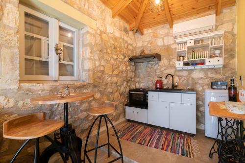 a kitchen with two bar stools in a stone wall at Dorothea Villa in Zakynthos Town