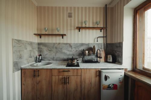 - une cuisine avec un évier et un comptoir dans l'établissement Двухкомнатная квартира в центре Versace, à Petropavlovsk-Kamtchatski