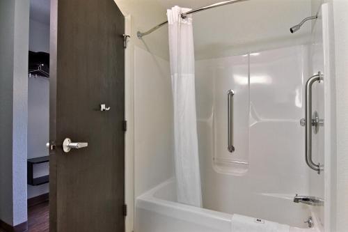ein Bad mit einer Badewanne und einer Dusche mit einem Duschvorhang in der Unterkunft Motel 6-Gilman, IL in Gilman