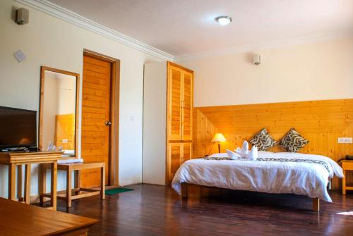 a bedroom with a bed and a flat screen tv at The Nature Residency - A Riverside Resort in Leh in Leh