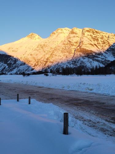 a snow covered mountain in front of a river at Studio 4 personnes équipé wifi in Bessans