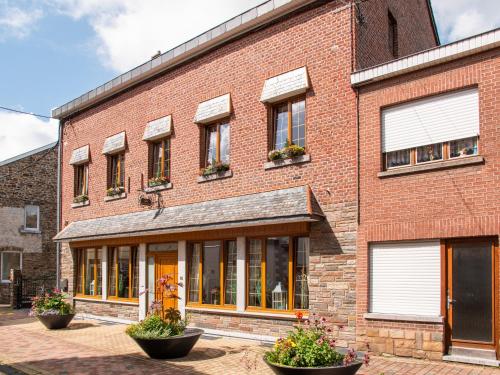 a red brick building with windows and plants at Gite les bons amis in Plombières
