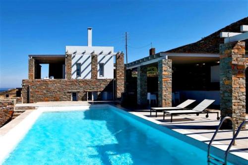 a swimming pool in front of a house at Villa Litharia, enchanting location and view in Ioulida