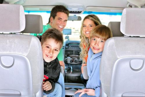 a family sitting in the back of a van at Country Inn & Suites by Radisson, Minot, ND in Minot