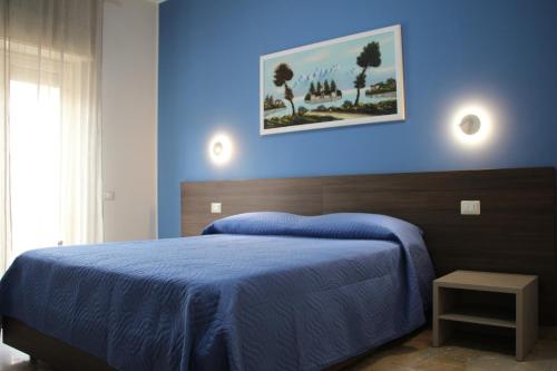 1 dormitorio azul con 1 cama con pared azul en B&B Delle Serre, en Messina