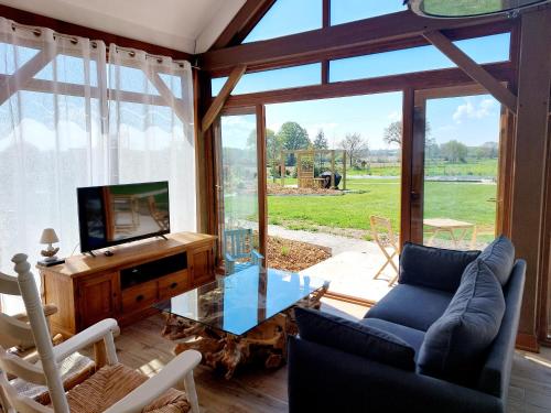 a living room with a tv and a glass table at Chambres d'hôtes chez l'habitant - Bed & Breakfast homestay in Huisnes-sur-Mer