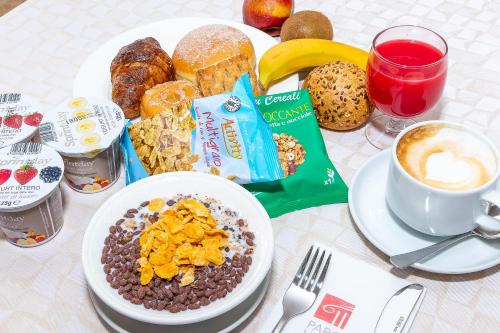 a table with a plate of breakfast food and a cup of coffee at Parc Hotel in Peschiera del Garda