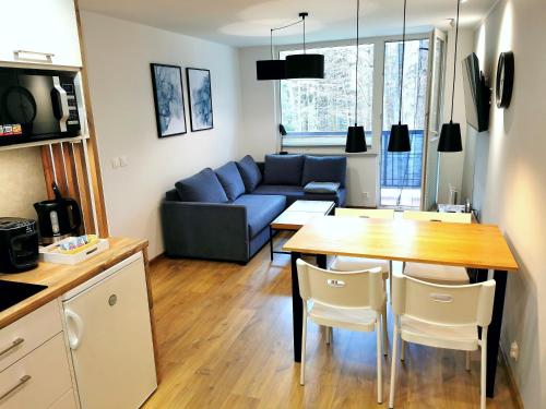 sala de estar con sofá azul y mesa en Apartament z Widokiem na Park en Polanica-Zdrój