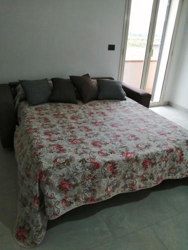 a bed with a flowered comforter in a bedroom at Villa Caterina in Solarino