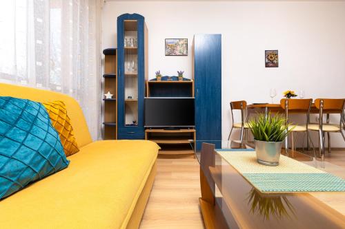 a living room with a yellow couch and a table at Lovely 1BD Apartment close to the Summer Theatre in Plovdiv
