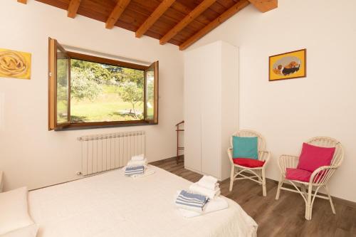 a bedroom with two chairs and a bed and a window at Modern apartment with 2 bedrooms Casa Perla by VacaVilla in Camaiore