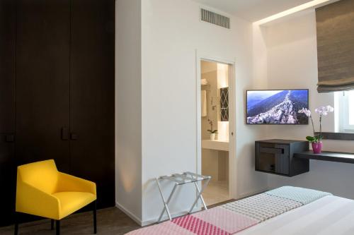a bedroom with a bed and a yellow chair at Il San Cristoforo in Ercolano