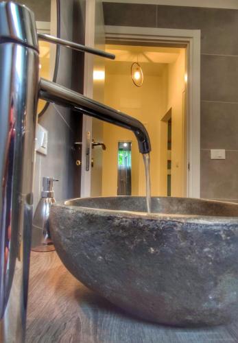 a bathroom with a stone sink with a water fountain at Aurora Flowers - Two rooms and free parking near center and train station in Modena