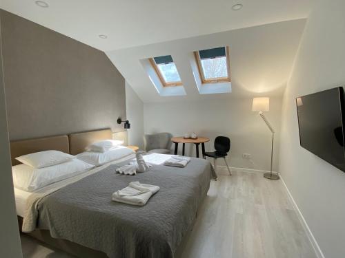 a bedroom with a bed with towels on it at Szkíta Panzió in Balatonmáriafürdő