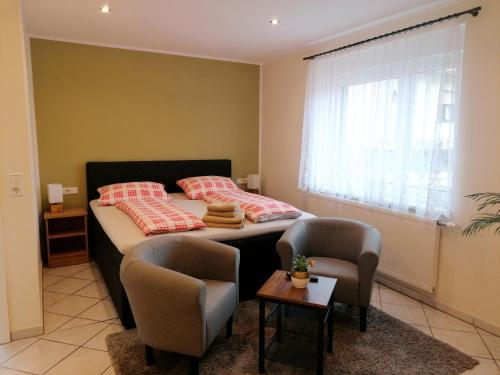 een slaapkamer met een bed met 2 stoelen en een raam bij Pension Lukask in Burg