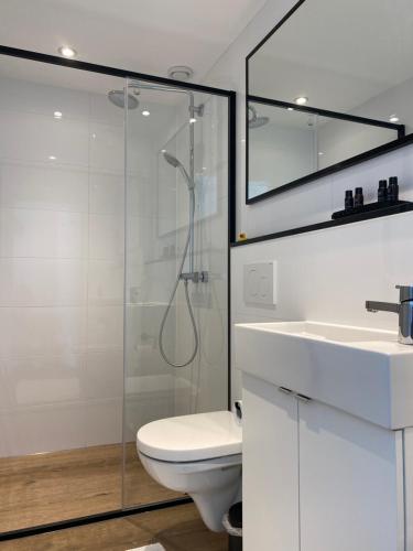 a bathroom with a shower and a toilet and a sink at Shorestay Zandvoort Beachhouse in Zandvoort