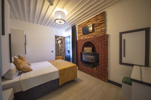 a bedroom with a bed and a brick fireplace at Mia Hotel in Antalya