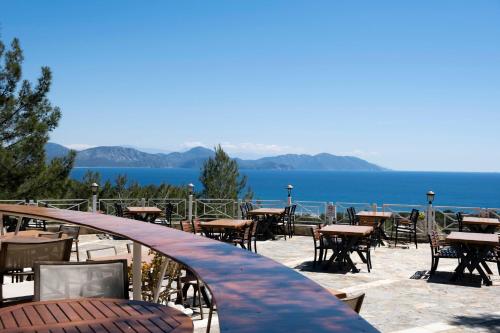 a row of tables and chairs with a view of the water at X Life Hotel Sarıgerme 15 - Adult Hotel in Sarigerme
