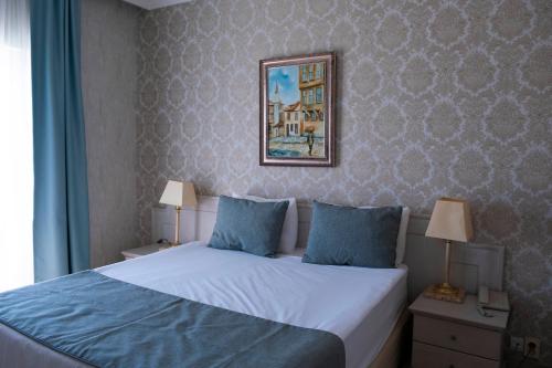 a bedroom with a bed and a picture on the wall at X Life Hotel Sarıgerme 15 - Adult Hotel in Sarigerme