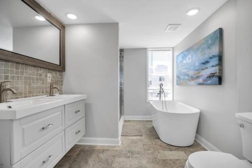 a bathroom with two sinks and a bath tub at Enjoy Your Stay in this Amazing Location in Philadelphia! home in Philadelphia