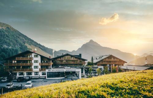 a group of buildings on a hill with a mountain at Wellnesshotel Warther Hof in Warth am Arlberg