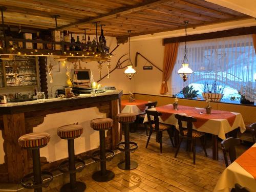 a restaurant with tables and chairs and a bar at Almhütte zwei Welten in Obervellach