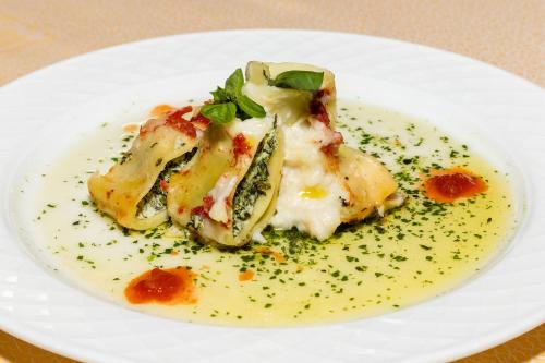 a white plate with food on a table at Parc Hotel Germano Suites & Apartments in Bardolino