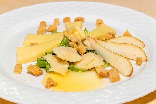 a white plate of food with apples and cheese at Parc Hotel Germano Suites & Apartments in Bardolino