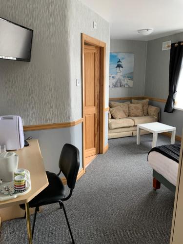 a room with a couch and a table and a chair at Kingscliff in Blackpool