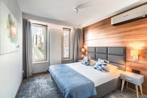 - une chambre avec un grand lit et un mur en bois dans l'établissement Park Apartments - Old Town, à Szczecin