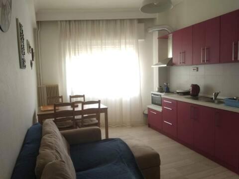 a living room with a blue couch and a kitchen at Square 2 in Komotini