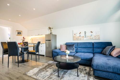 a living room with a blue couch and a table at Deluxe Apartments Franjkovic in Seliste Dreznicko
