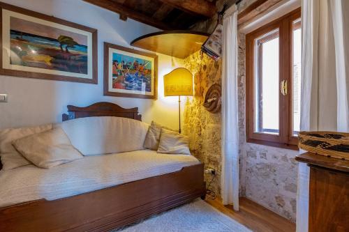 una cama en una habitación con ventana en Chalet vista mare Free wi-fi e Aria condizionata, en Alghero