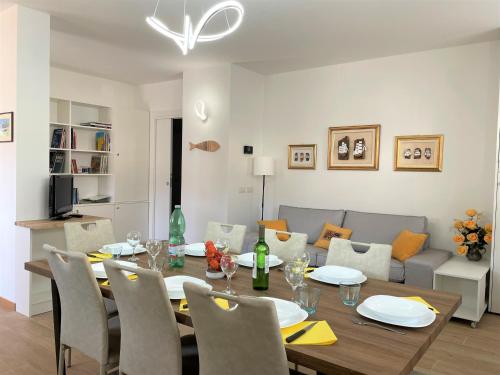 comedor y sala de estar con mesa y sillas en GIORNI FELICI: appartamento tutto nuovo, giardino, parcheggio, en Verbania