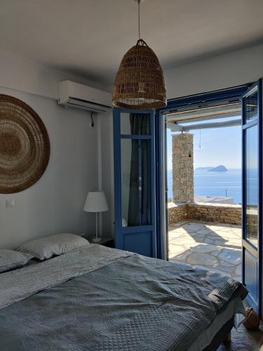 a bedroom with a bed and a view of the ocean at Aeraki in Kithnos