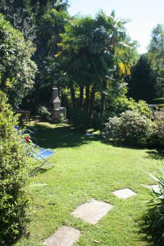 a yard with a lawn with a grave and trees at Villa dei Fiori in Luino