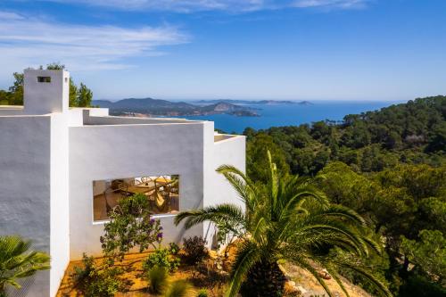 biały dom z widokiem na ocean w obiekcie Villa El Mirador Uno w mieście Es Cubells