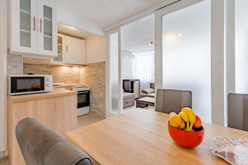 uma cozinha com uma mesa e uma taça de fruta em Apartment Eli em Split