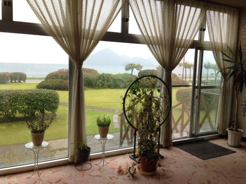 a room with a large window with potted plants at Hokkai Hotel in Lake Toya
