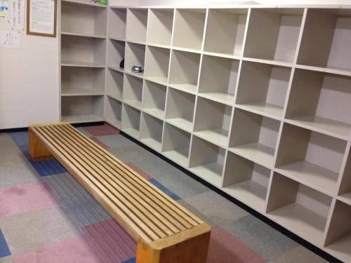 a library with a wooden bench in front of shelves at Hokkai Hotel in Lake Toya