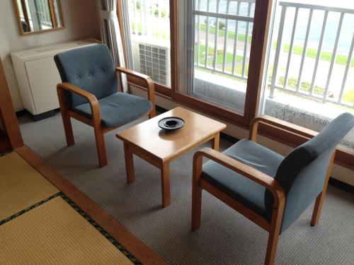 a living room with two chairs and a table at Hokkai Hotel in Lake Toya