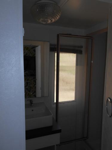 a bathroom with a sink and a mirror at Camping Les Roussilles in Saint-Sylvestre