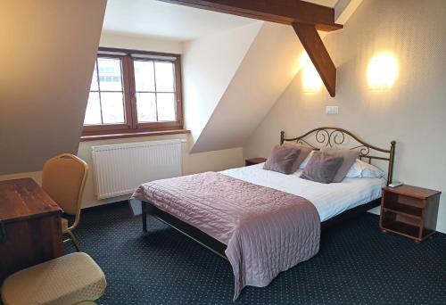 a bedroom with a bed and a desk and a chair at Hotel Beskidzki Raj Medical SPA in Stryszawa