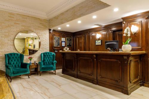 a luxury lobby with two blue chairs and a mirror at Golden Crown Hotel in Istanbul