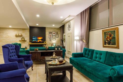a living room with green couch and blue chairs at Golden Crown Hotel in Istanbul