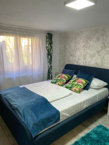 a large bed with a blue headboard in a bedroom at Kaya Home in Sibiu