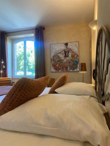 a bedroom with a bed and a painting on the wall at Auberge Du Roua in Argelès-sur-Mer