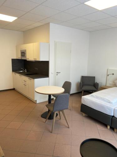 um quarto com uma cama, uma mesa e cadeiras em Nord-Ries Apartments em Fremdingen