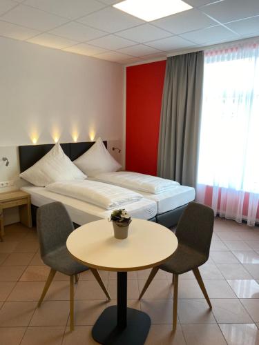 um quarto de hotel com uma cama, uma mesa e cadeiras em Nord-Ries Apartments em Fremdingen