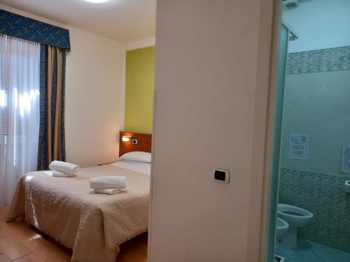 um quarto com uma cama e uma casa de banho com um WC em La Casa Dell'Arte srl em Roma
